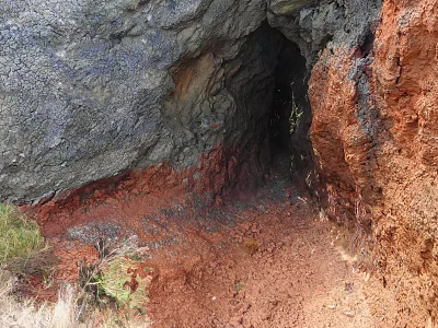 Scenic Cave Entrance With Gray And Red Rocks Red Soil And Green Plants 3d model