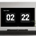 Modern TV Displaying April 2022 Date 02 22 On Black Stand With Plant