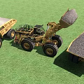 Red And Yellow Cranes At Construction Site With Green Grass And Distant Buildings