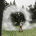 Photo Check-in Spot With Foggy Ring On Grassland Surrounded by Trees And Standing Person