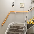 Modern Staircase With Wooden Handrail And Glass Railings Framed Pictures And Yellow Flowers