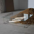 Modern Minimalist Glass Top Coffee Table with Metal Frame and Sand Pile in Indoor Setting