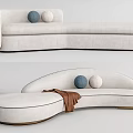 White Curved Sectional Sofa With Blue Beige Cushions And Brown Throw Blanket