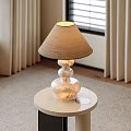Beige Fabric Lampshade Table Lamp With Transparent Stacked Spherical Base On White Round Table