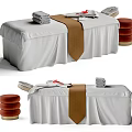 Elegant Massage Bed Setup With White Sheets Brown Towel And Stacked Towels