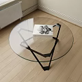 Round Glass Top Coffee Table With Black Metal Base And Modern Design Book