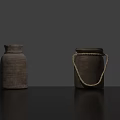 Two Textured Clay Jars One With Rope Handle On Black Tabletop Against Gray Background