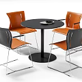 Modern Minimalist Round Table with Black Top and Orange Cushioned Chairs Silver Metal Legs