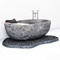 Stone Bathtub on Pebble Base with Wooden Tray Holding Black Towels Against White Walls