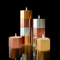 Lit Metallic Colored Candle Lamps In Gold Copper Silver With Multiple Stacked Sizes