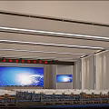Large Modern Conference Room With Multiple Blue Screens Arranged Seats And Ceiling Lighting