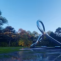 Curved Stainless Steel Sculpture in Outdoor Park with Green Trees and Shining Light