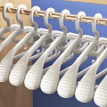 White Plastic Hangers Hanging On Metal Rod For Daily Household Use