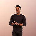 Man Wearing Black Long Sleeve Top Black Pants With Clasped Hands Wristwatch Gradient Brown Background