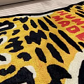 Vibrant Tiger Shaped Rug with HUMAN MADE Lettering on Wooden Floor