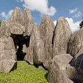 Garden Ornament With Natural Rock Formations Green Grass And Trees Under Blue Sky