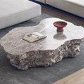 Irregular Shaped Marble Coffee Table With Open Book And Brown Bowl On Gray Rug