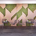 Geometric Wooden Moss Wall Floral Art Installation with Metal Tables and Small Potted Plants