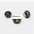 Three Black Ceramic Jars With Green Vine Patterns On White Background