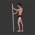 Shirtless Man in Black Underwear Standing with Long Pole Against Gray Background on Black Floor