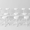 Wheeled Stools With Blue And Gray Seats Against White Wall On Gray Carpet