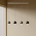 Four Modern Spherical Pendant Lights Hanging In Interior With Light Colored Wall And Window Blinds
