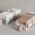 Elegant massage beds with cream and white linens and matching stools.