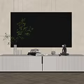 White Ribbed TV Stand With Large TV Green Plant And Decorative Figurines