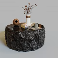 Black Round Coffee Table With Textured Surface And Vase Dried Flowers Books Small Pottery Jar