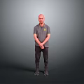 Man Standing in Gray Polo Shirt with Yellow Logo and Hands Crossed on Gray Background