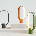 Modern Minimalist Table Lamps In Black Orange Green With Circular Design On White Platforms