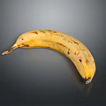 Ripe Yellow Banana with Brown Spots Isolated on Dark Background Close Up View
