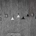 Various Designed Pendant Lights Hanging Against Rough Textured Wall Background