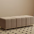 Light Beige Upholstered Stool with Vertical Tufted Design and Gold Metal Legs on Patterned Rug