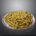 Yellow noodles on white plate with red rim against black background