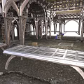 Ornate Arched Metal Structures With Large Workbench Tables And Textured Flooring