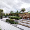 Serene Outdoor Garden Patio With Gray Sofa Dining Table And Lush Green Vines