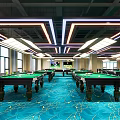Modern Billiard Room With Multiple Tables Green Felt Surfaces Blue Patterned Carpet And Large Windows