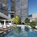 Modern Twin Tower Office Building Connected by Sky Bridge in Urban Setting With Greenery