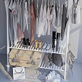 Different Colored Clothes Hanging On Rack With Coats Shirts Boots Suitcase Bags And Umbrella