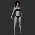 Woman in Black Bikini with Short Hair Standing Against Gray Background