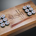 Assorted Sushi Rolls On Wooden Tray With Chopsticks And Engraved Sushi