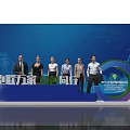 Group Photo Spot at International Energy Transition Forum With Power Towers Wind Turbines Stage Backdrop