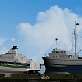 Modern Ferry and Vintage Sailing Boat on Calm Water with Blue Sky White Clouds