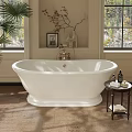 White Freestanding Bathtub With Brass Faucet Beside Window Small Table Palm Plant And Decorative Items