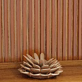 Decorative Flower Shaped Ornament Set On Wooden Tabletop With Striped Wall