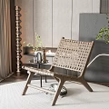 Modern Woven Leisure Chair With Wooden Frame On Round Rug Near Fireplace And Green Plant