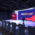 Event Stage Setup With Large Screen Camera And White Chairs For Life Aesthetics