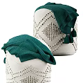 White Woven Ottoman With Green Tasseled Blanket And Raised Geometric Design