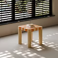 Square Coffee Table Featuring Orange White Checkerboard Top Light Cylindrical Legs and Sunlight Shadows